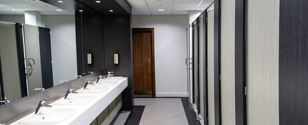 Public bathroom with sinks, mirrors and cubicles